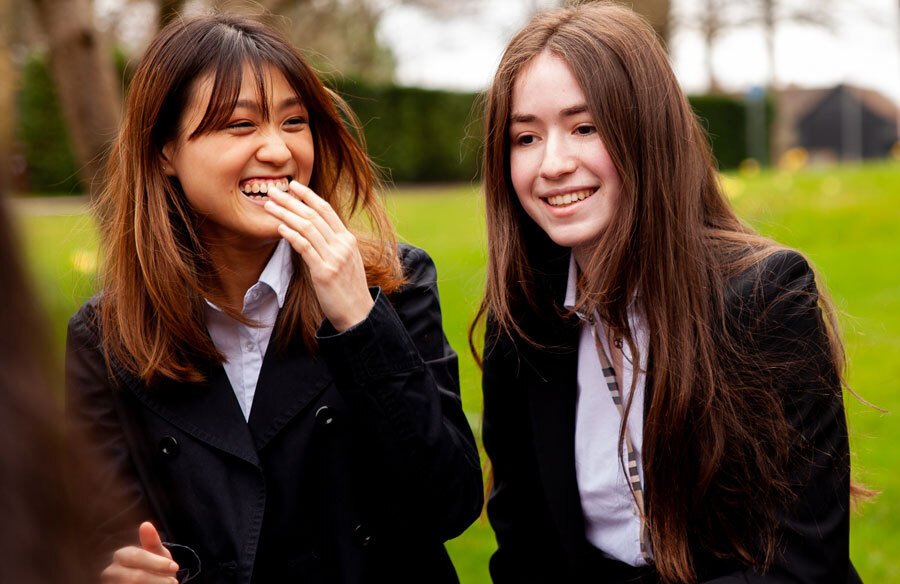 St Margarets School boarding pupil laughing with friends outside school