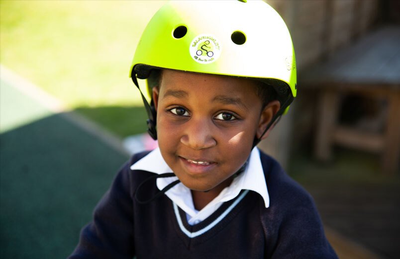 St Margarets School Balanceability workshop Junior School pupil wearing cycle helmet and enjoying bike riding lesson