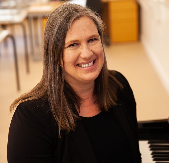 St Margarets School Director of Music sitting at a piano